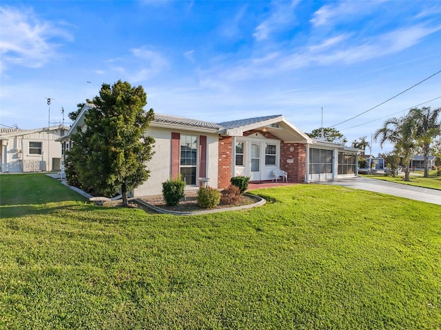 6536 Beach Blvd, Hudson, FL 34667 - ranch-style home featuring concrete driveway, an attached garage, a front lawn, and brick siding