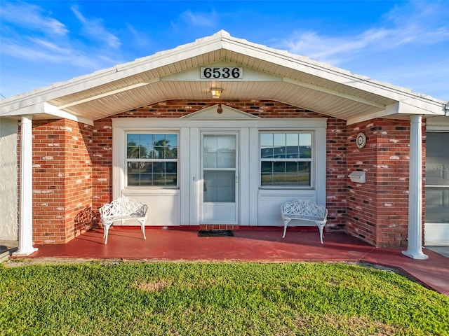 6536 Beach Blvd, Hudson, FL 34667 - view of exterior entry with a porch and brick siding