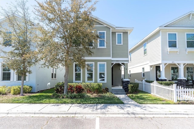 3465 Bumelia Ln, New Port Richey, FL 34655 - view of front facade featuring stucco siding, fence, and a front lawn