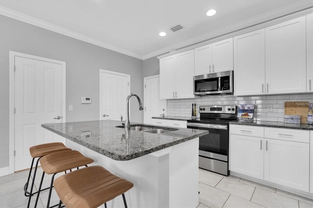 3465 Bumelia Ln, New Port Richey, FL 34655 - kitchen with crown molding, a sink, appliances with stainless steel finishes, a kitchen island with sink, and visible vents