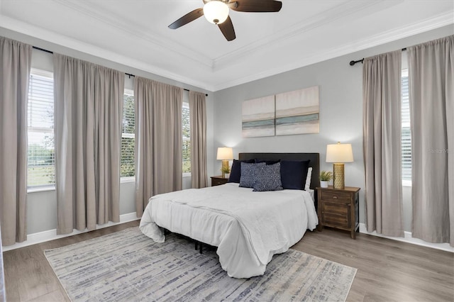 3465 Bumelia Ln, New Port Richey, FL 34655 - bedroom with a tray ceiling, multiple windows, wood finished floors, and ornamental molding