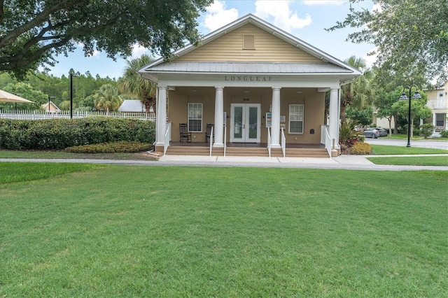 3465 Bumelia Ln, New Port Richey, FL 34655 - rear view of property featuring covered porch, french doors, fence, metal roof, and a lawn