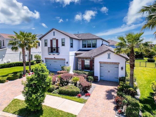 view of front of property with decorative driveway, stucco siding, a front yard, and fence