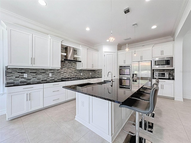 kitchen featuring crown molding, wall chimney exhaust hood, a sink, appliances with stainless steel finishes, and light tile patterned floors