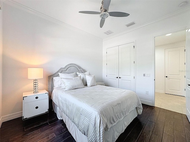 bedroom featuring a closet, ornamental molding, dark wood-type flooring, and visible vents