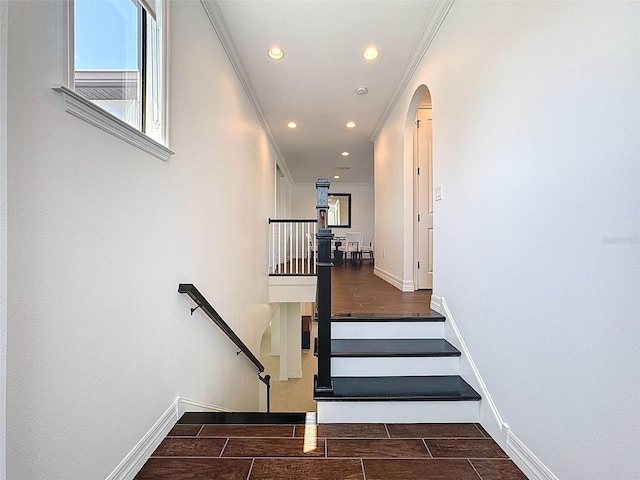 stairs with baseboards, recessed lighting, and arched walkways