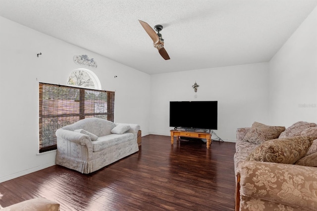 living room featuring a textured ceiling, wood finished floors, baseboards, and a ceiling fan