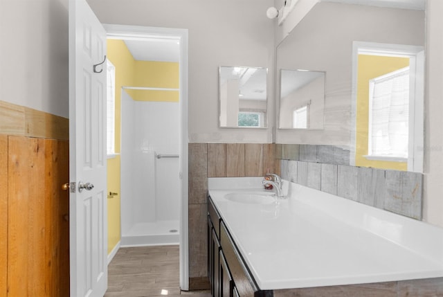 full bath featuring wood finished floors, vanity, and a shower stall