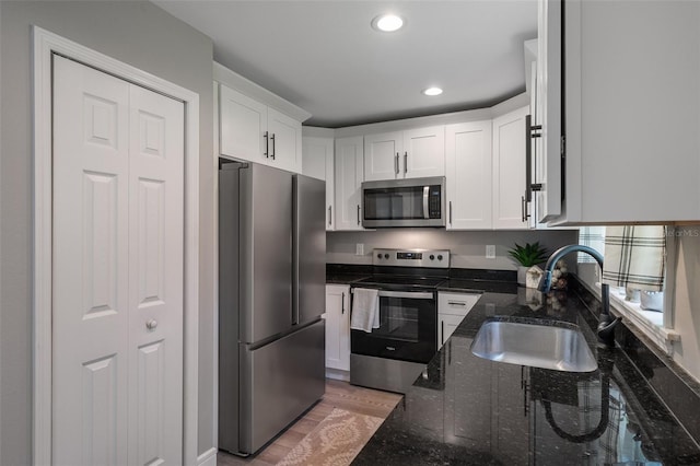 604 Kinnear Dr, Brooksville, FL 34601 - kitchen featuring appliances with stainless steel finishes, a sink, white cabinetry, dark stone countertops, and recessed lighting