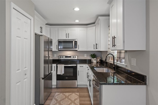 604 Kinnear Dr, Brooksville, FL 34601 - kitchen featuring appliances with stainless steel finishes, a sink, white cabinetry, light wood finished floors, and recessed lighting