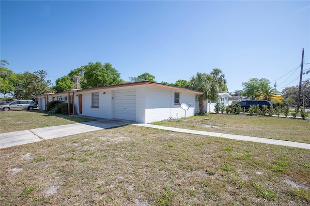5800 Madison St, New Port Richey, FL 34652 - view of side of property with concrete driveway, a garage, and a lawn