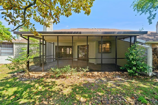 back of house featuring a sunroom and a chimney