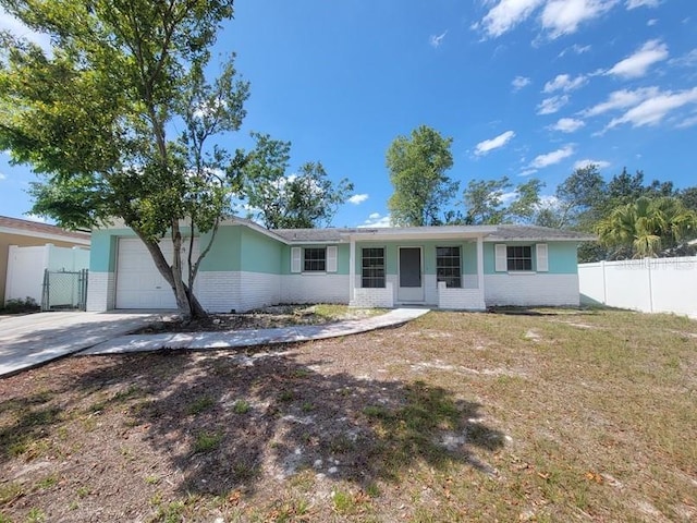 ranch-style house featuring driveway, brick siding, and fence