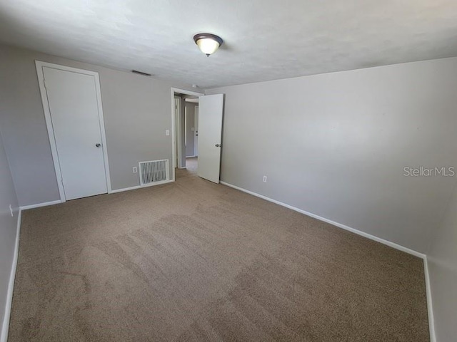 unfurnished bedroom featuring carpet flooring, baseboards, and visible vents