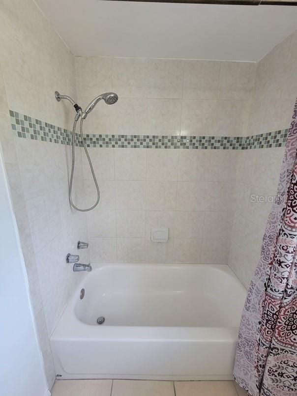 full bath featuring tile patterned flooring and shower / bath combination with curtain