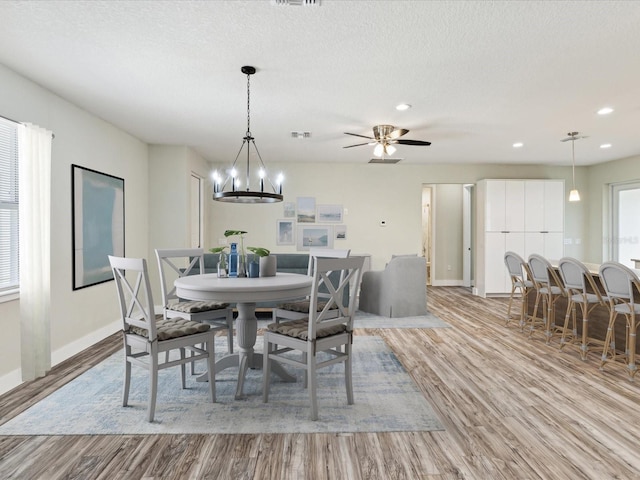 dining area featuring wood finished floors, a textured ceiling, baseboards, visible vents, and recessed lighting