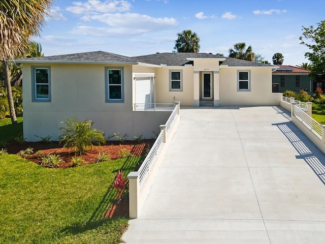 view of front of house featuring a front yard, fence, and stucco siding