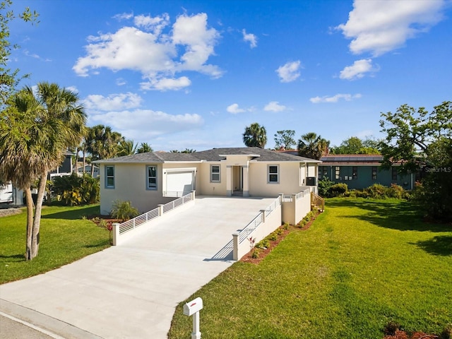 back of property with a yard, stucco siding, an attached garage, and concrete driveway