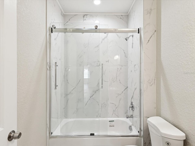 full bath featuring toilet, shower / bath combination with glass door, and a textured wall