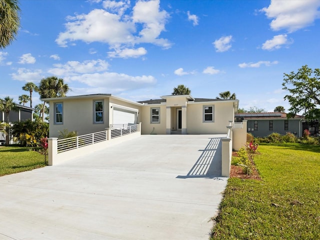 view of front facade featuring stucco siding, a garage, a front lawn, and concrete driveway