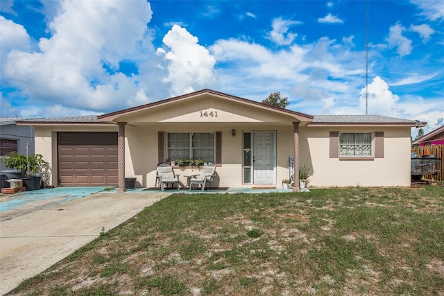 ranch-style house with covered porch, a front yard, driveway, and a garage