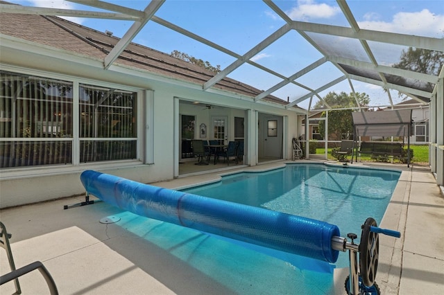 pool with glass enclosure and a patio area