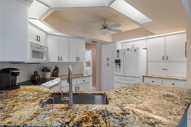 kitchen with white appliances, ceiling fan, tasteful backsplash, and light stone counters