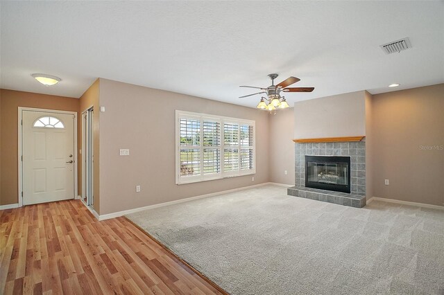 7355 SE 106th Pl, Belleview, FL 34420 - unfurnished living room featuring a ceiling fan, baseboards, a tile fireplace, and light wood-style flooring