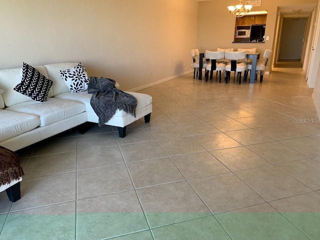 2600 Ocean Shore Blvd Unit 111, Ormond Beach, FL 32176 - living room with tile patterned floors, a chandelier, and baseboards