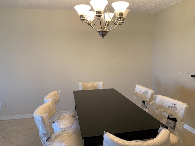 2600 Ocean Shore Blvd Unit 111, Ormond Beach, FL 32176 - dining space featuring a chandelier, a textured ceiling, light tile patterned flooring, and baseboards