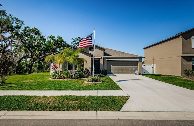 36419 Flats St, Zephyrhills, FL 33541 - view of front of house featuring stucco siding, concrete driveway, an attached garage, and a gate