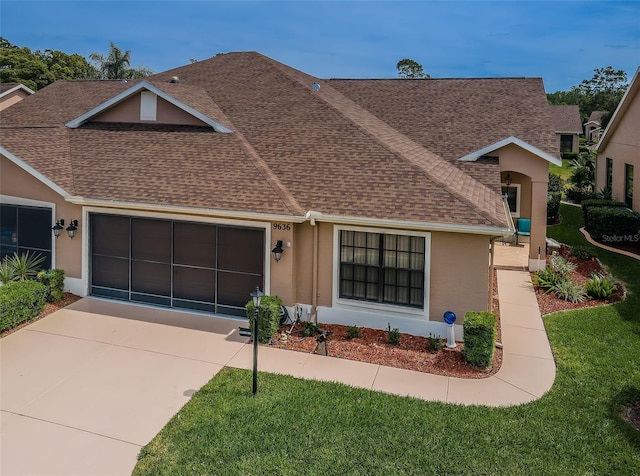 9636 Brookdale Dr, New Port Richey, FL 34655 - view of front of house featuring driveway, stucco siding, a garage, and roof with shingles