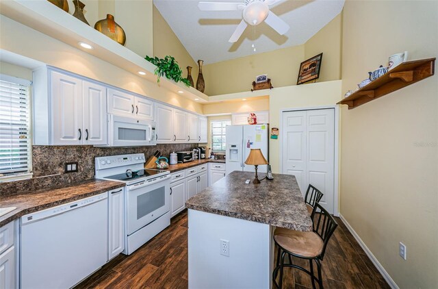 9636 Brookdale Dr, New Port Richey, FL 34655 - kitchen featuring a breakfast bar, white cabinetry, dark countertops, and white appliances