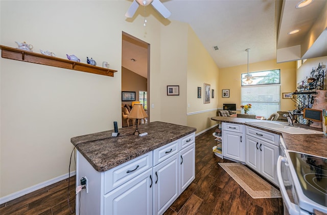 9636 Brookdale Dr, New Port Richey, FL 34655 - kitchen with dark countertops, white cabinets, ceiling fan, and a sink