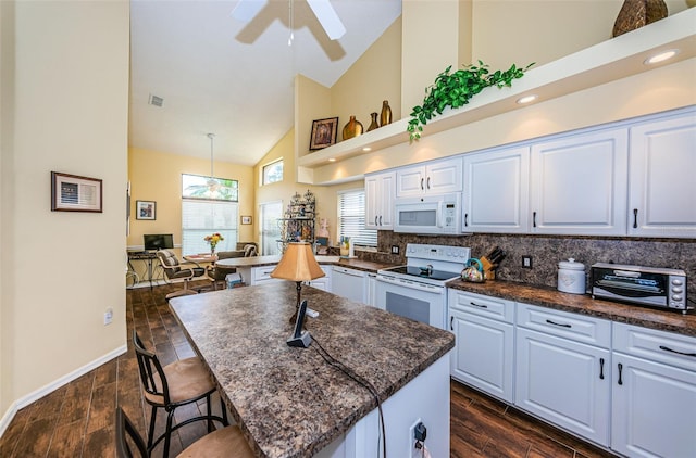 9636 Brookdale Dr, New Port Richey, FL 34655 - kitchen featuring a kitchen breakfast bar, visible vents, dark wood-style floors, and white appliances
