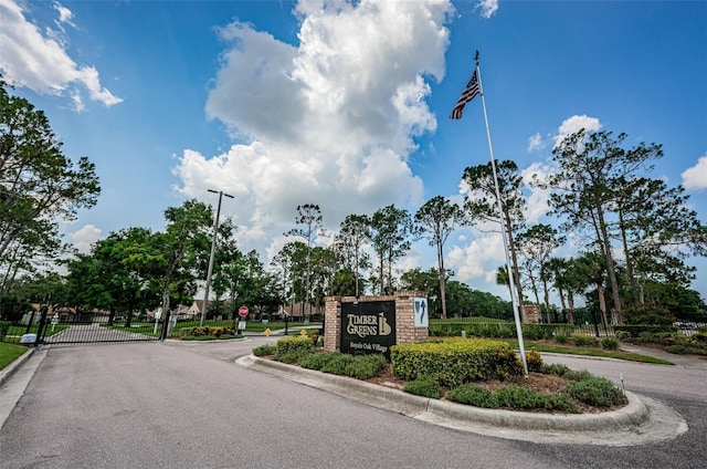 9636 Brookdale Dr, New Port Richey, FL 34655 - view of road featuring a gate, curbs, traffic signs, street lights, and a gated entry