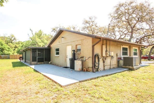 rear view of house featuring a sunroom, fence, a patio, a lawn, and cooling unit