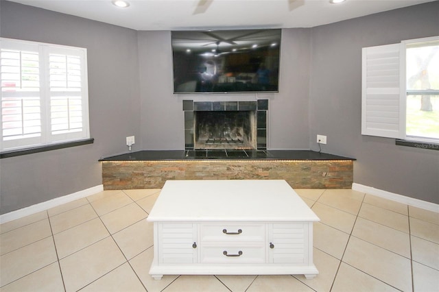 unfurnished living room with baseboards, a fireplace, recessed lighting, and light tile patterned floors