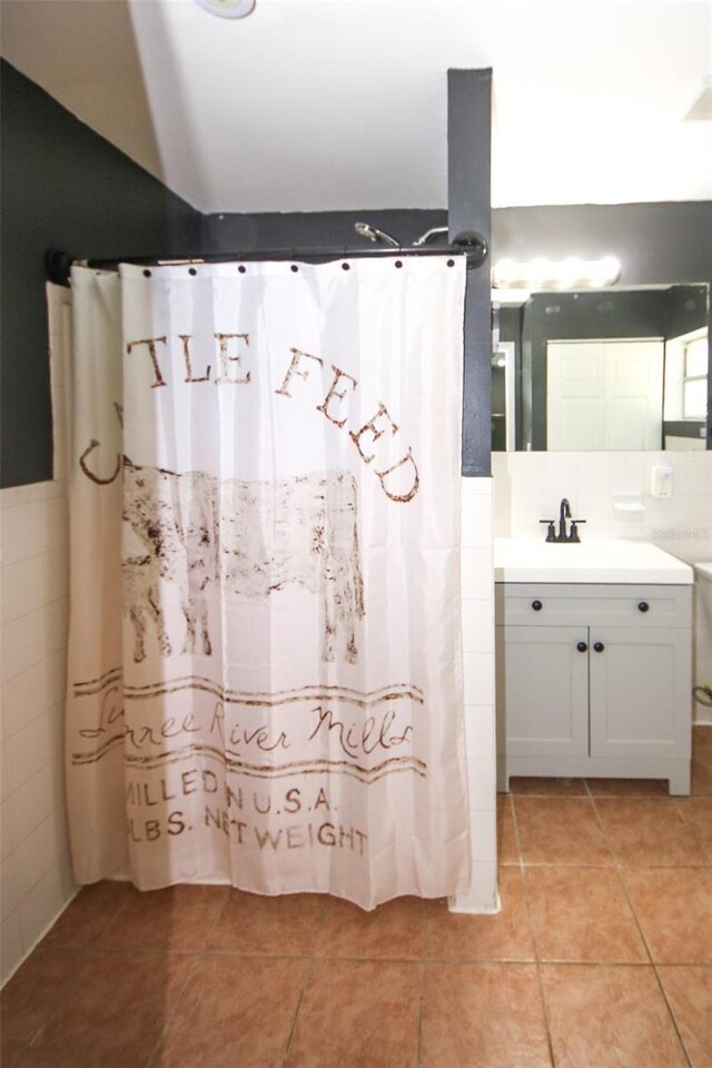 full bathroom with tile walls, tile patterned floors, and vanity