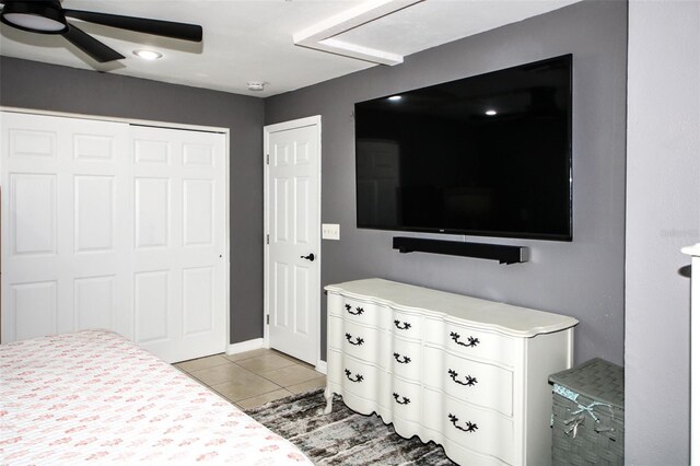 bedroom featuring light tile patterned floors, a closet, and ceiling fan
