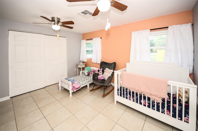 tiled bedroom featuring baseboards, a closet, ceiling fan, and visible vents