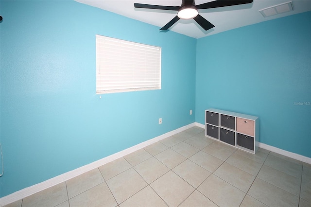 unfurnished room with baseboards, a ceiling fan, visible vents, and light tile patterned floors