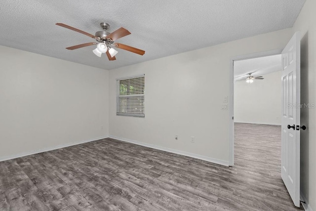 spare room with a textured ceiling, a ceiling fan, and wood finished floors