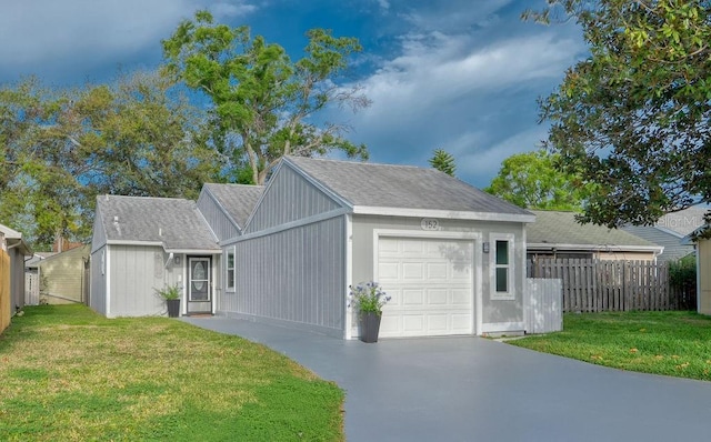 view of front of home with fence, an attached garage, driveway, and a front lawn