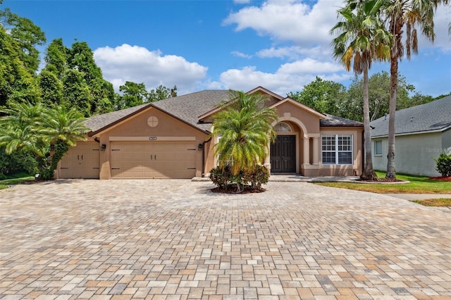 view of front of home with an attached garage, stucco siding, and driveway
