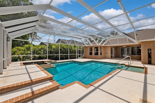 view of swimming pool featuring glass enclosure, a patio, and a pool with connected hot tub