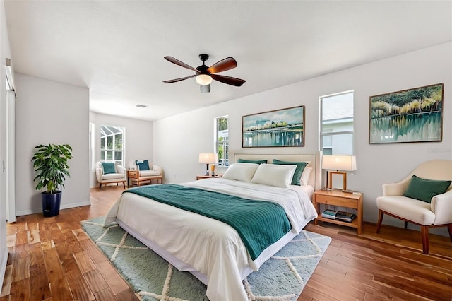 bedroom featuring baseboards, a ceiling fan, and wood finished floors