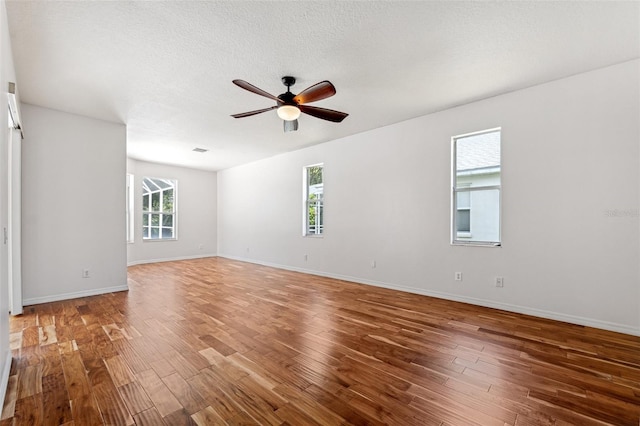 spare room with baseboards, a ceiling fan, and wood finished floors