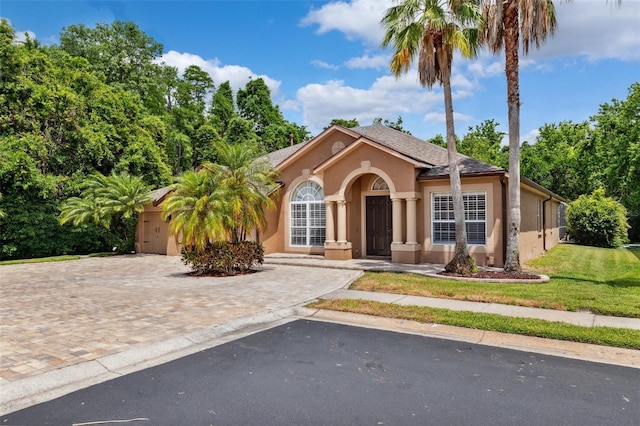 view of front of property with stucco siding, driveway, and a front yard