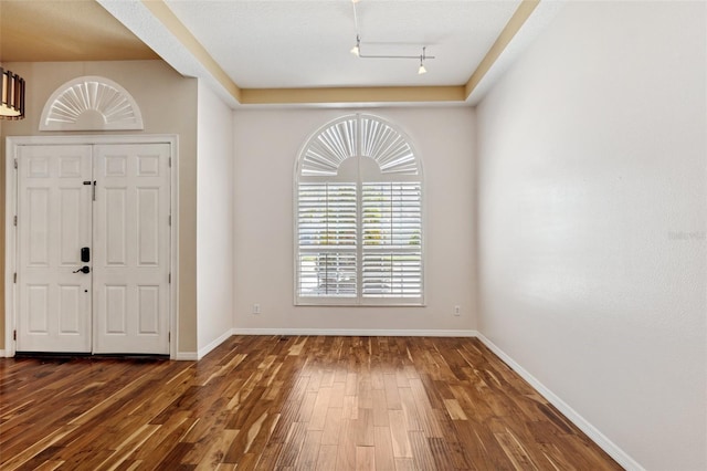 foyer entrance featuring track lighting, baseboards, and wood finished floors